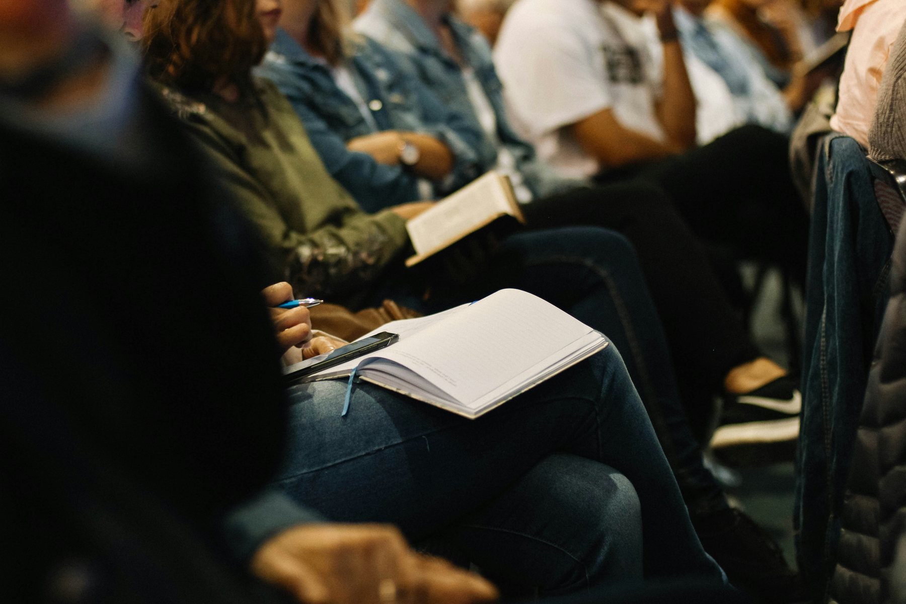 Persone sedute durante un incontro, con una Bibbia e un quaderno aperti.